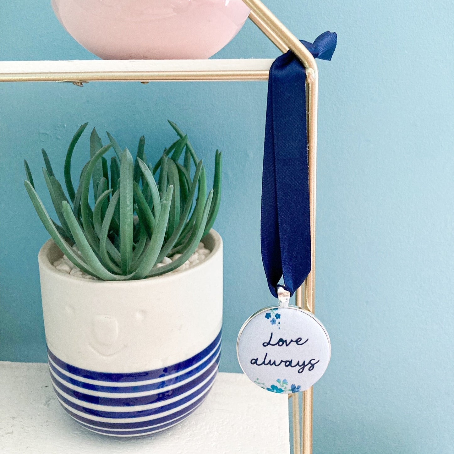 Keepsake with Love Always printed on a blue floral fabric with a navy blue ribbon