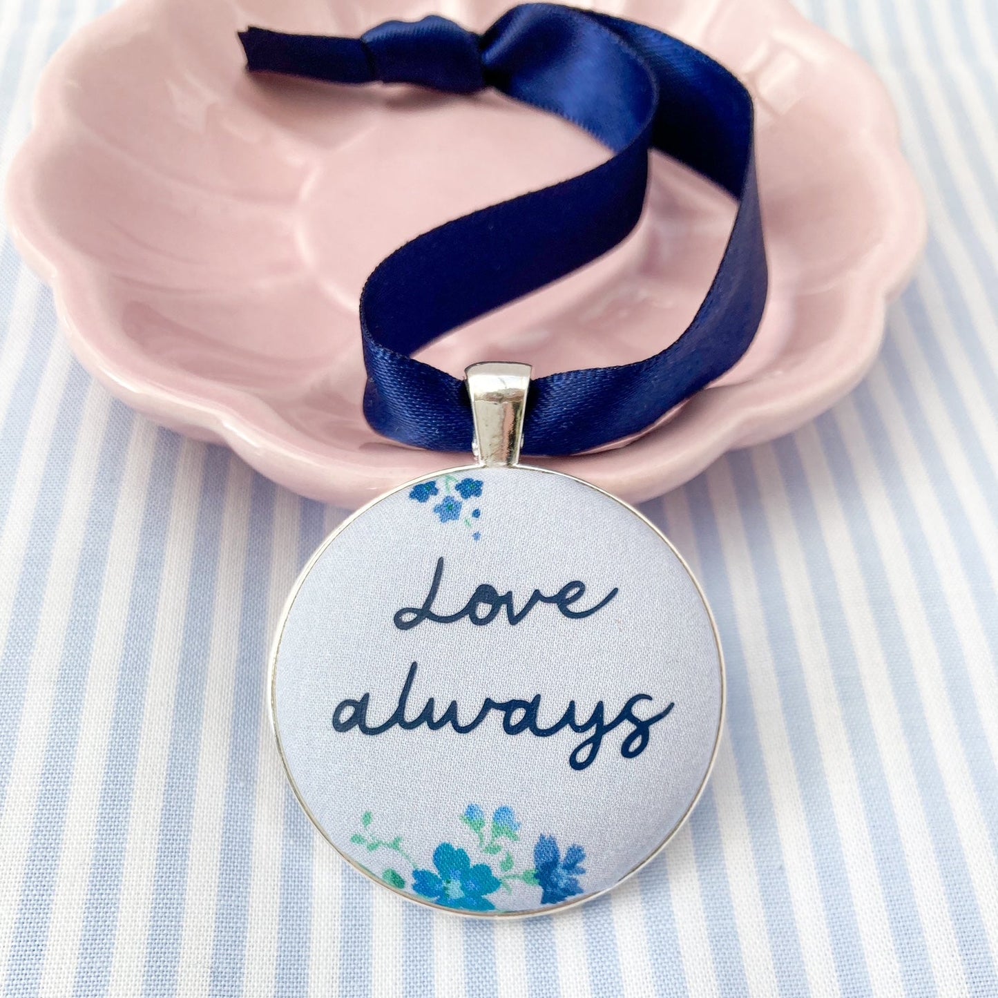 Keepsake with Love Always printed on a blue floral fabric with a navy blue ribbon