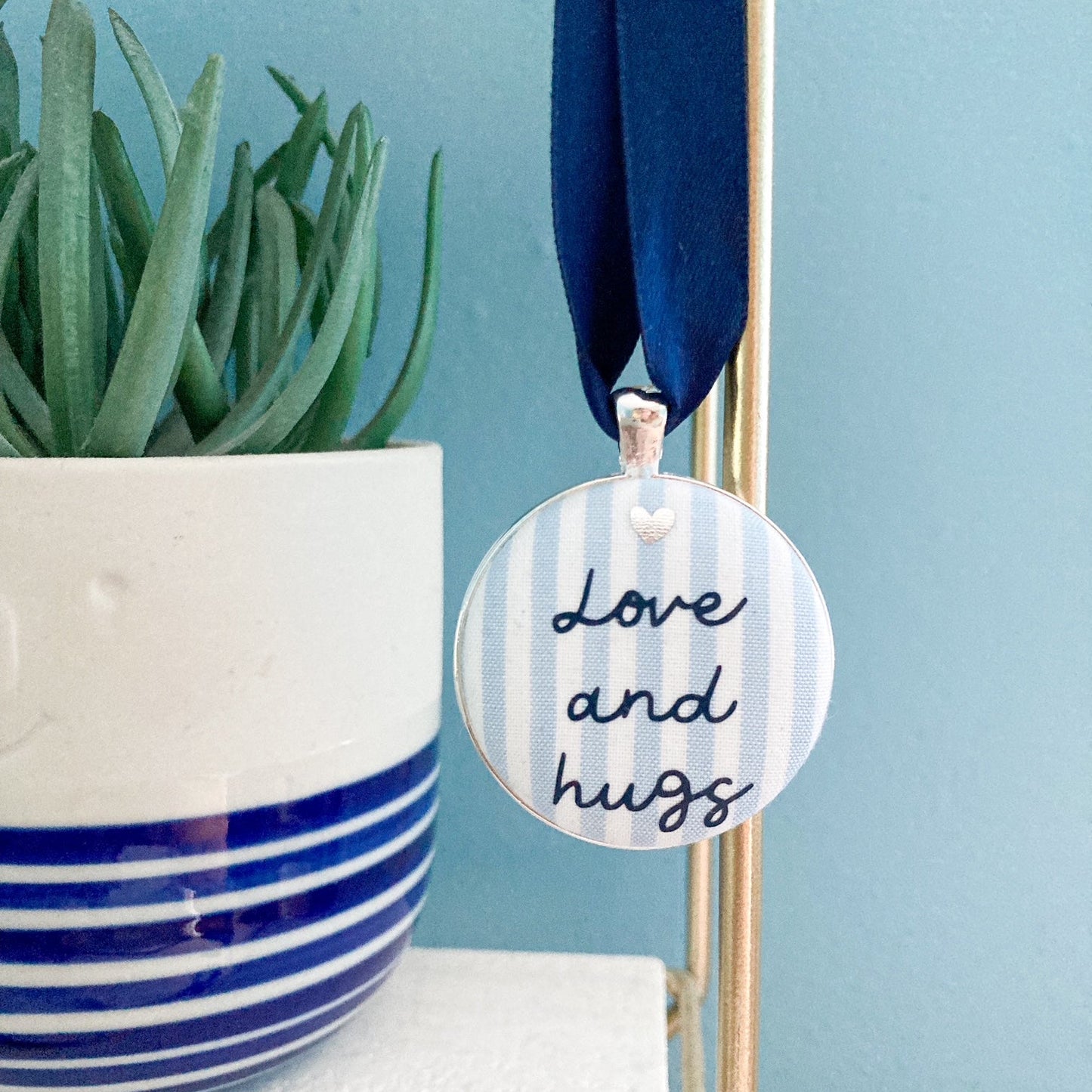 Love and Hugs keepsake made with blue and white striped fabric and a navy blue ribbon