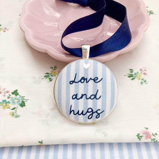 Love and Hugs keepsake made with blue and white striped fabric and a navy blue ribbon