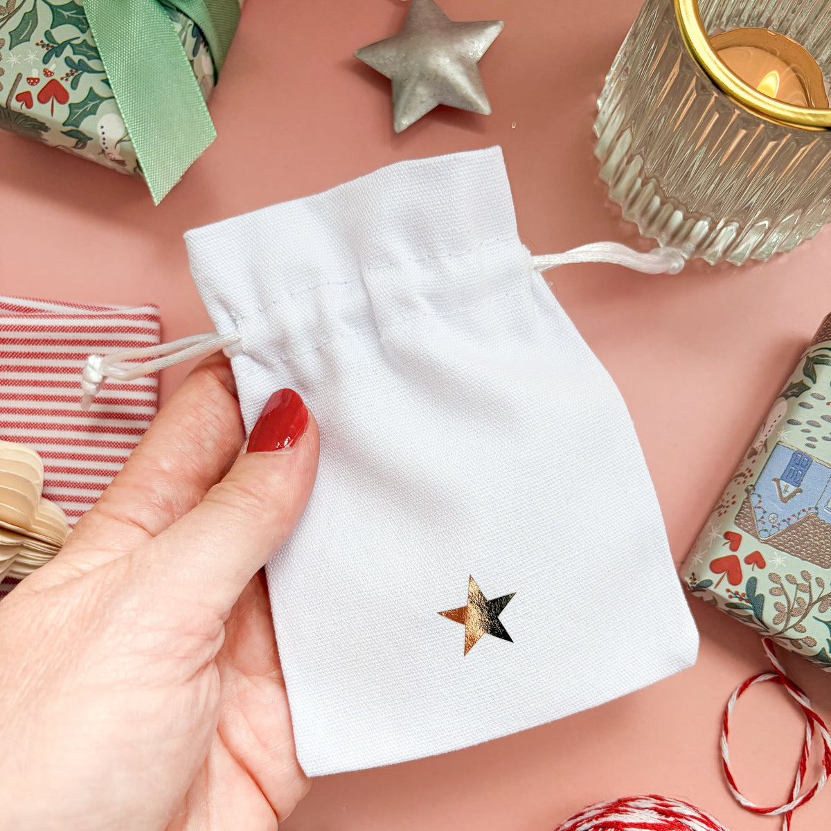 Christmas drawstring gift pouch with gold star with a Christmassy flaylay