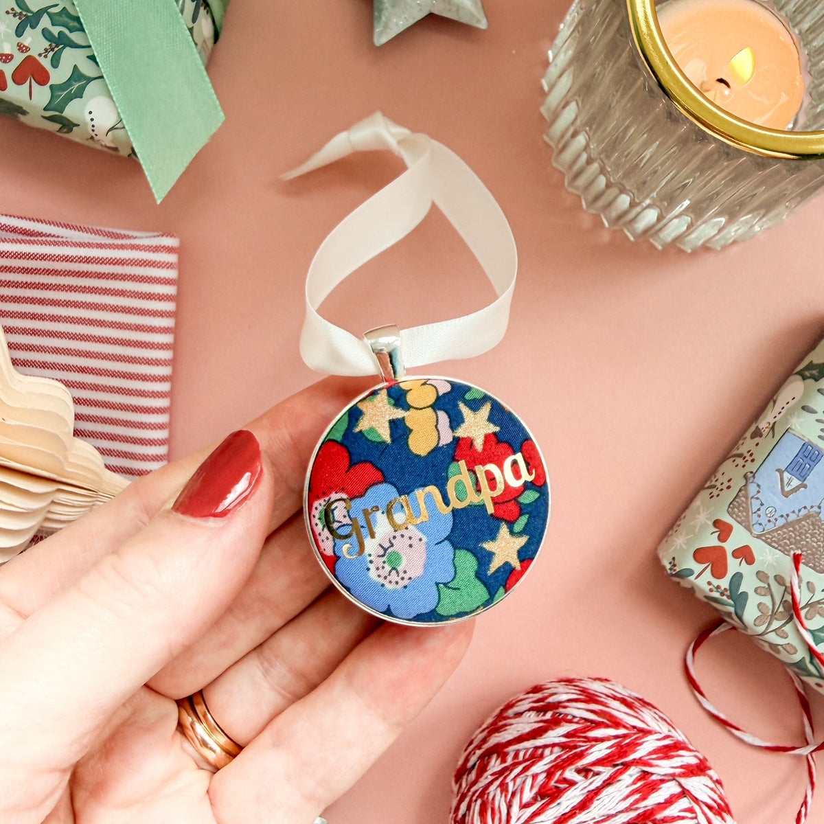 Christmas Grandpa keepsake or memory keepsake to hang on the tree, made with blue floral Liberty fabric, printed with Grandpa in gold foil, thread on ivory satin ribbon, set on a Christmas flatlay