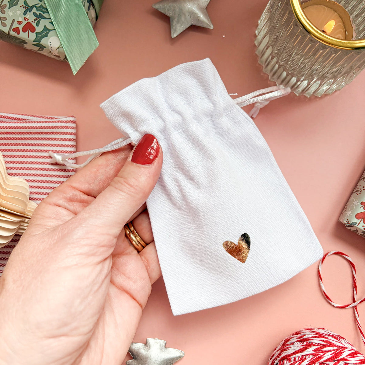 White drawstring gift pouch with a gold foil heart