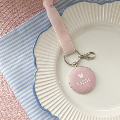 Pink keepsake and keyring thread on a velvet ribbon with 'FAITH' and a white heart printed onto pink fabric