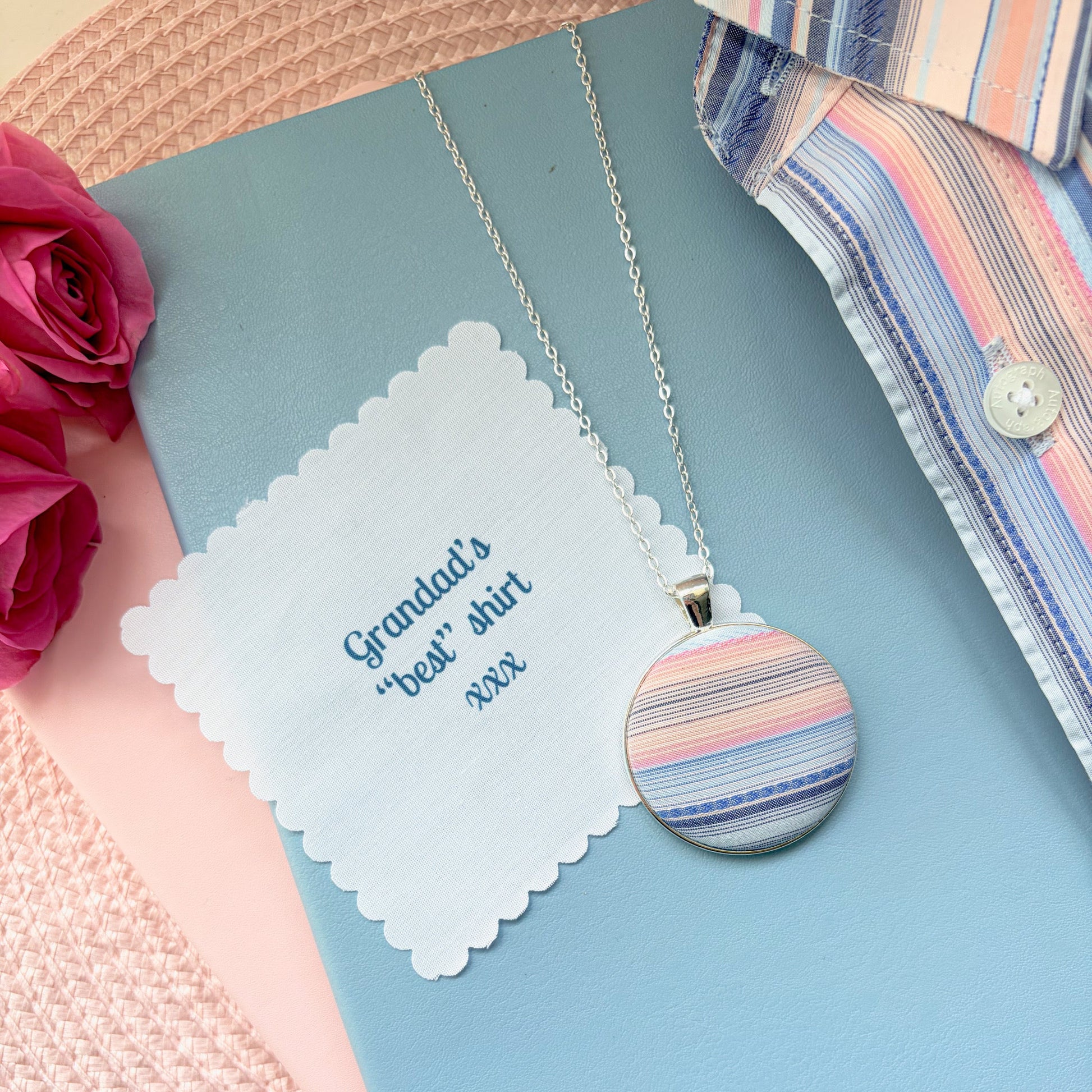 Necklace with a striped pendant with 'Grandad's best shirt' text, surrounded by flowers and fabric.