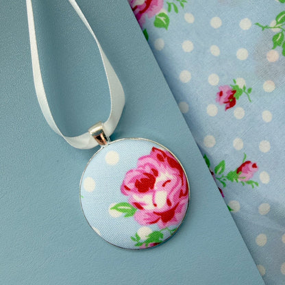 Grans apron memory keepsake, thread on a ribbon, set on a blue notebook