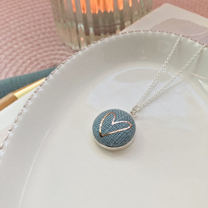 Necklace with a heart-shaped pendant on a white dish with a blurred background
