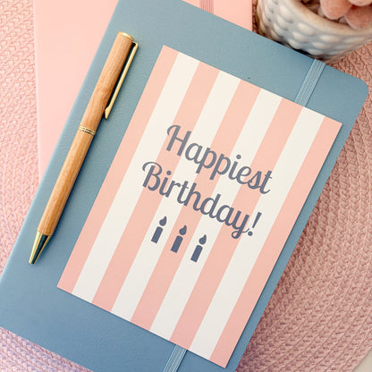 Happiest Birthday postcard with a pink and white striped design and blue candles