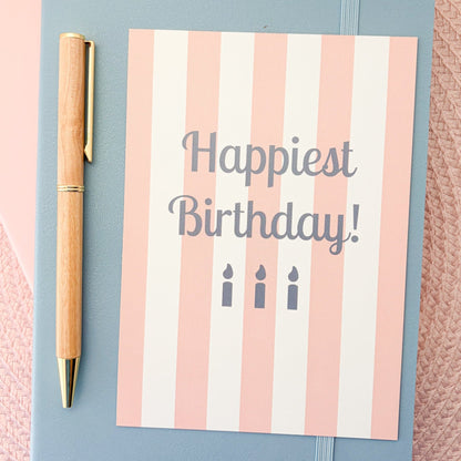 Happiest Birthday postcard with a pink and white striped design and blue candles
