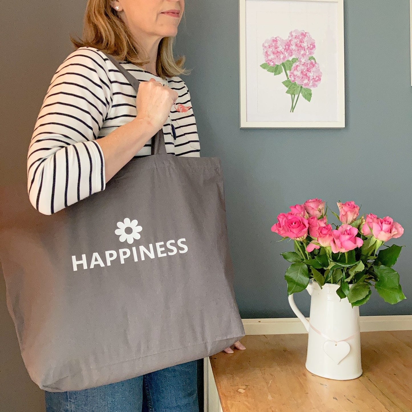 Grey tote bag printed with Happiness and a flower