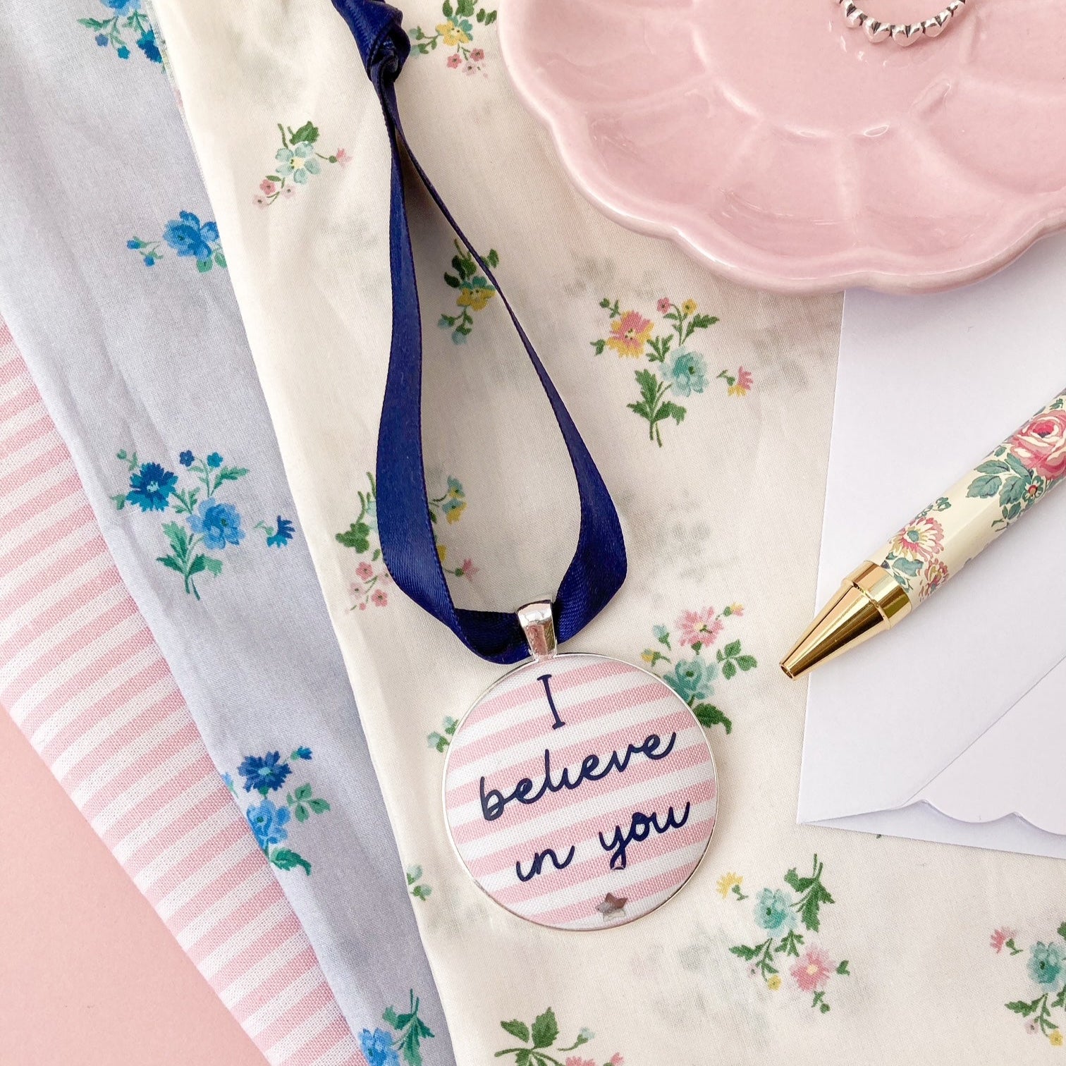 Keepsake with I believe in you printed onto pink and whtie striped fabric, with a navy blue ribbon