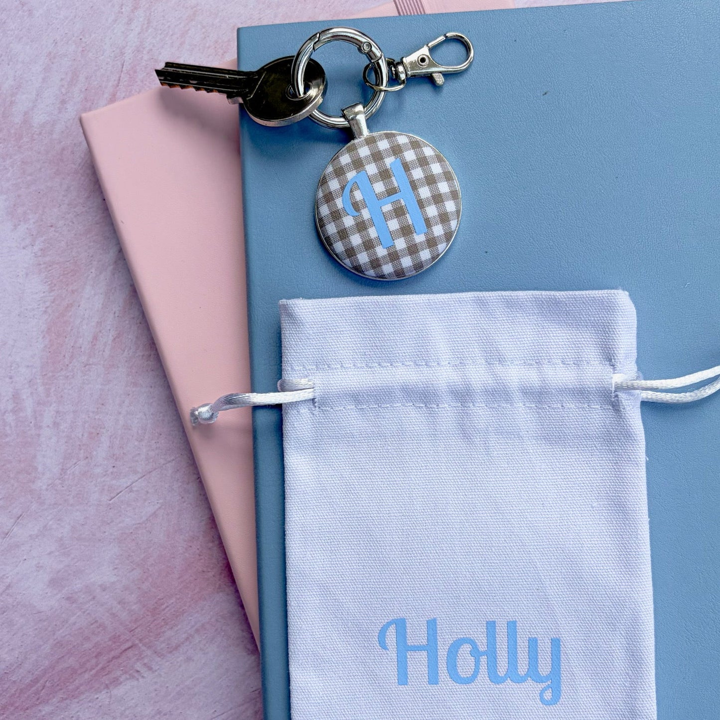 Keyring with caramel gingham fabric and blue H initial design with a personalised white gift pouch