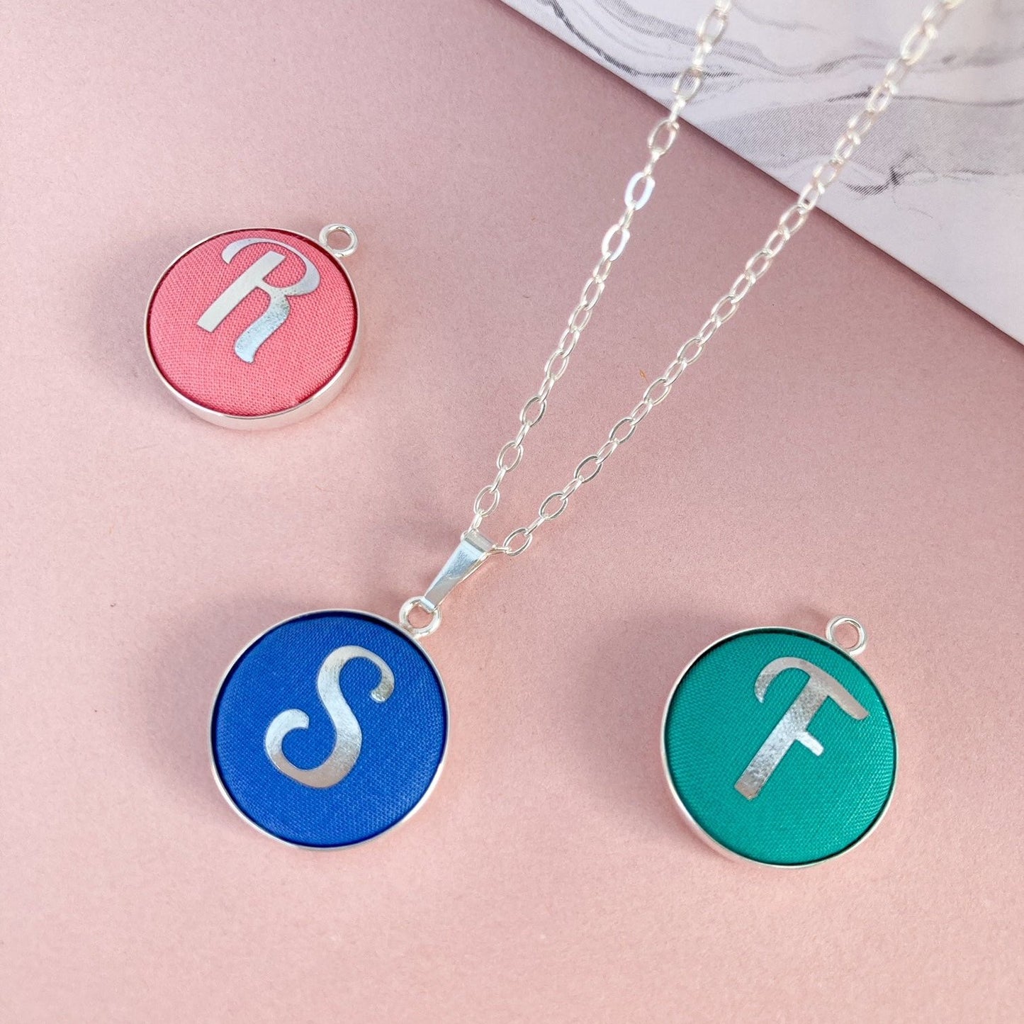 Brightly coloured fabric initial necklaces