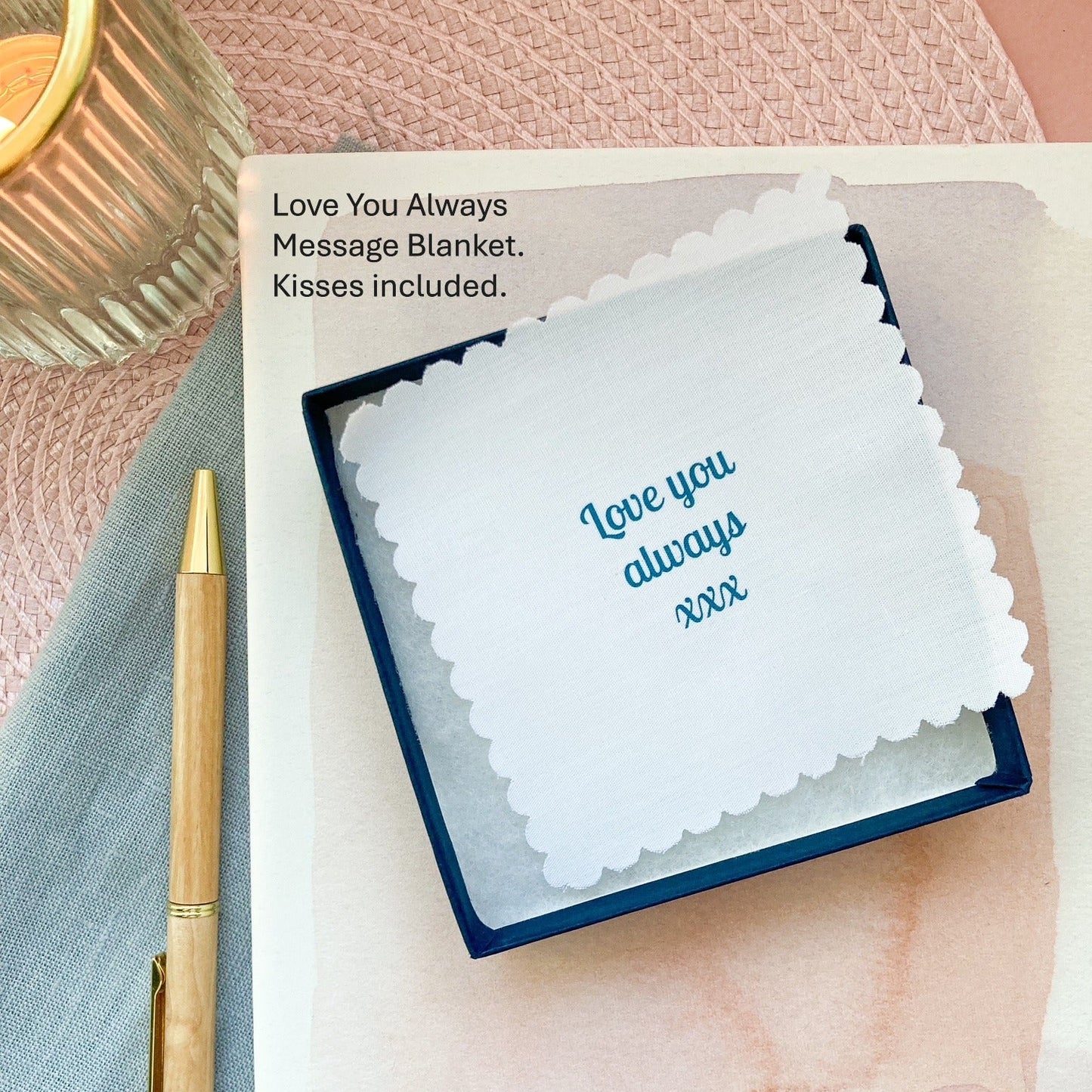 "Love you always" message blanket in a jewellery box and pen on a textured surface
