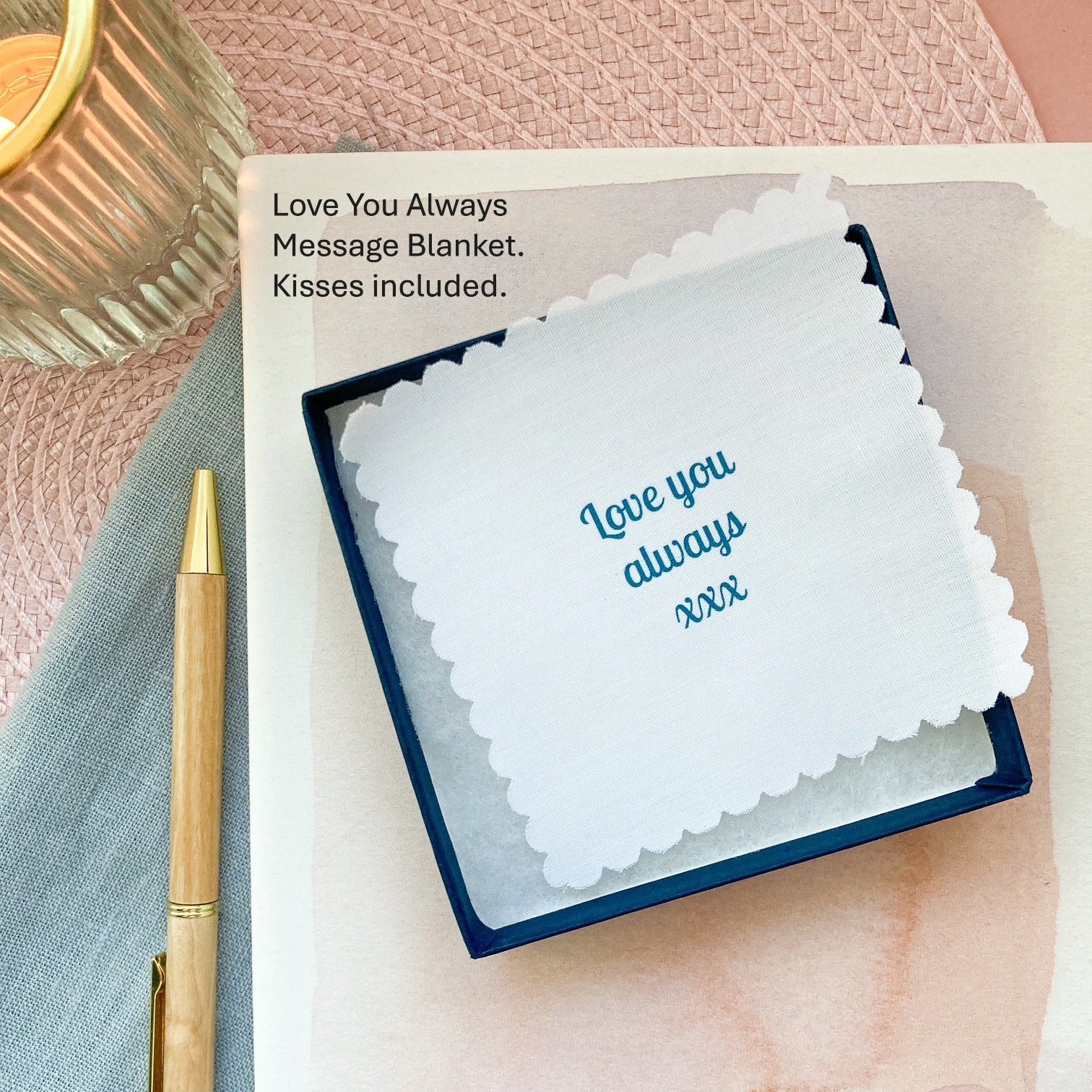 "Love you always" message blanket in a jewellery box and pen on a textured surface