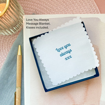 "Love you always" message blanket in a jewellery box and pen on a textured surface