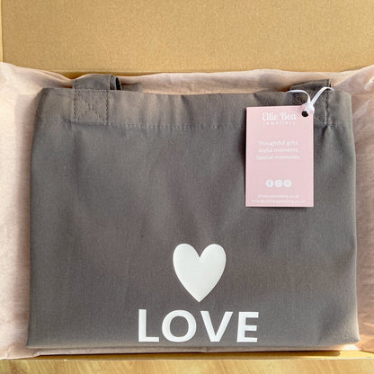 Love tote bag wrapped in tissue in a mailing box