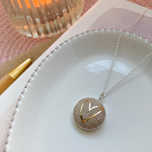 Necklace with a heart-shaped pendant on a white dish with a blurred background