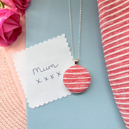 Necklace with a red and white striped pendant with 'Mum' and 'xxx' text, surrounded by pink flowers and a red and white striped fabric.