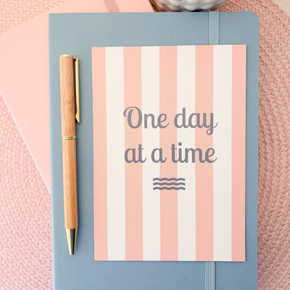 One Day At A Time postcard with a pink and white striped design 