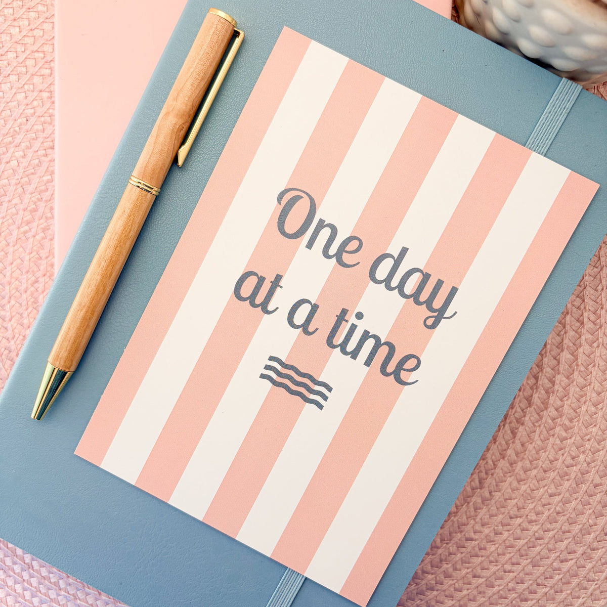 One Day At A Time postcard with a pink and white striped design 