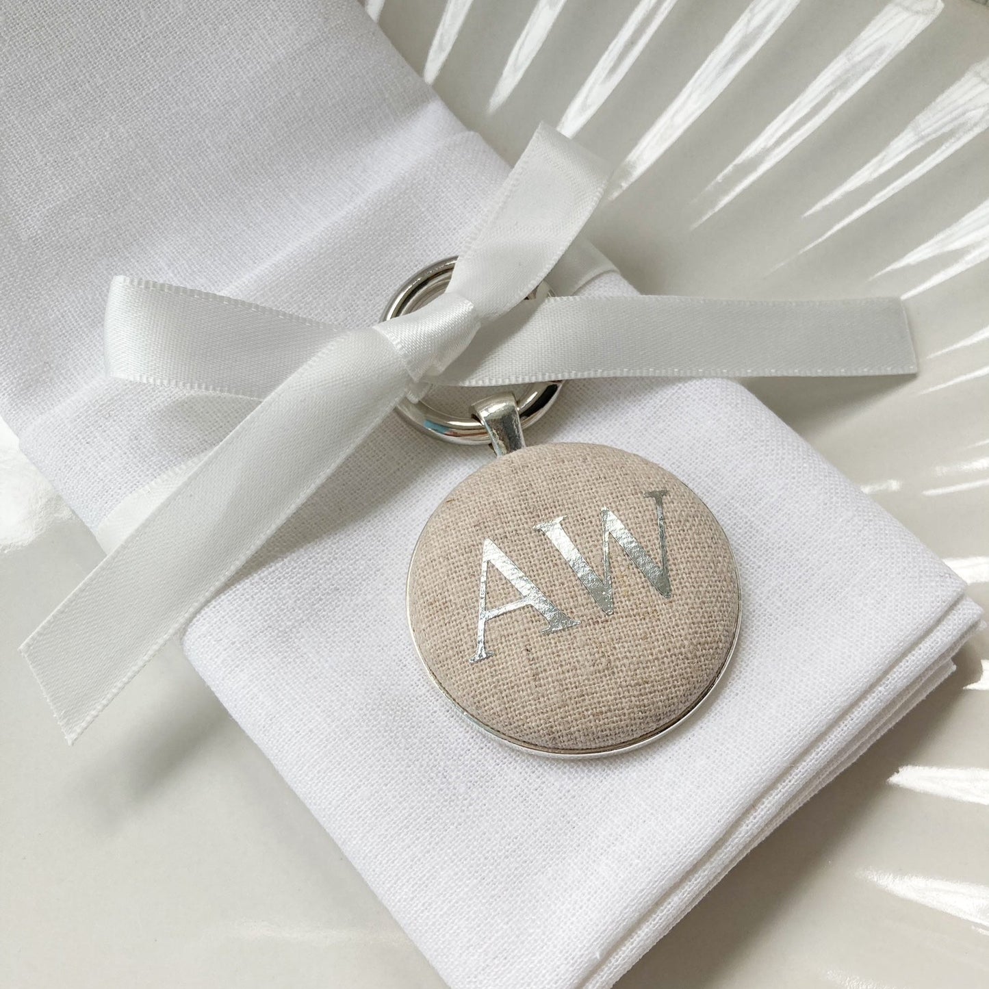 Personalised wedding breakfast place setting and favour keyring in natural linen fabric with initials