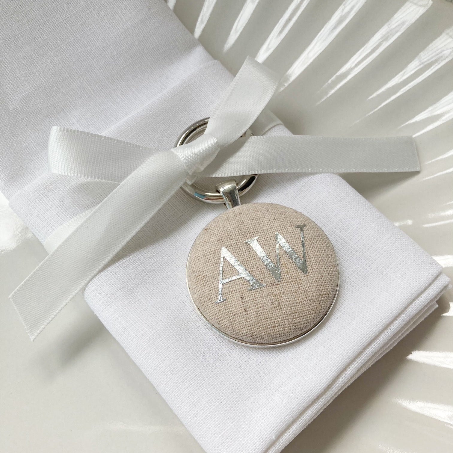 Personalised wedding breakfast place setting and favour keyring in natural linen fabric with initials