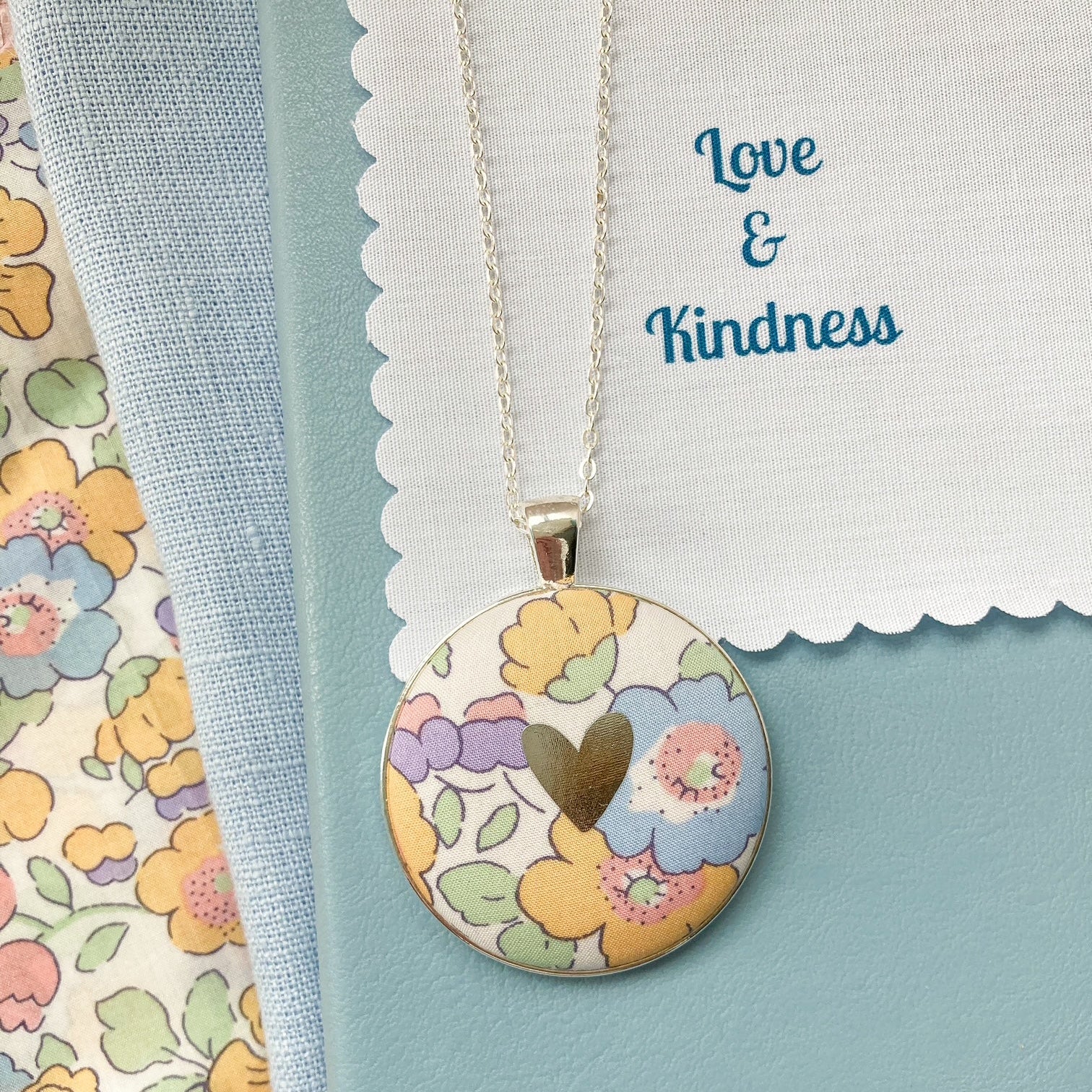 Yellow & lilac floral fabric necklace with a fabric message saying "Love & Kindness"