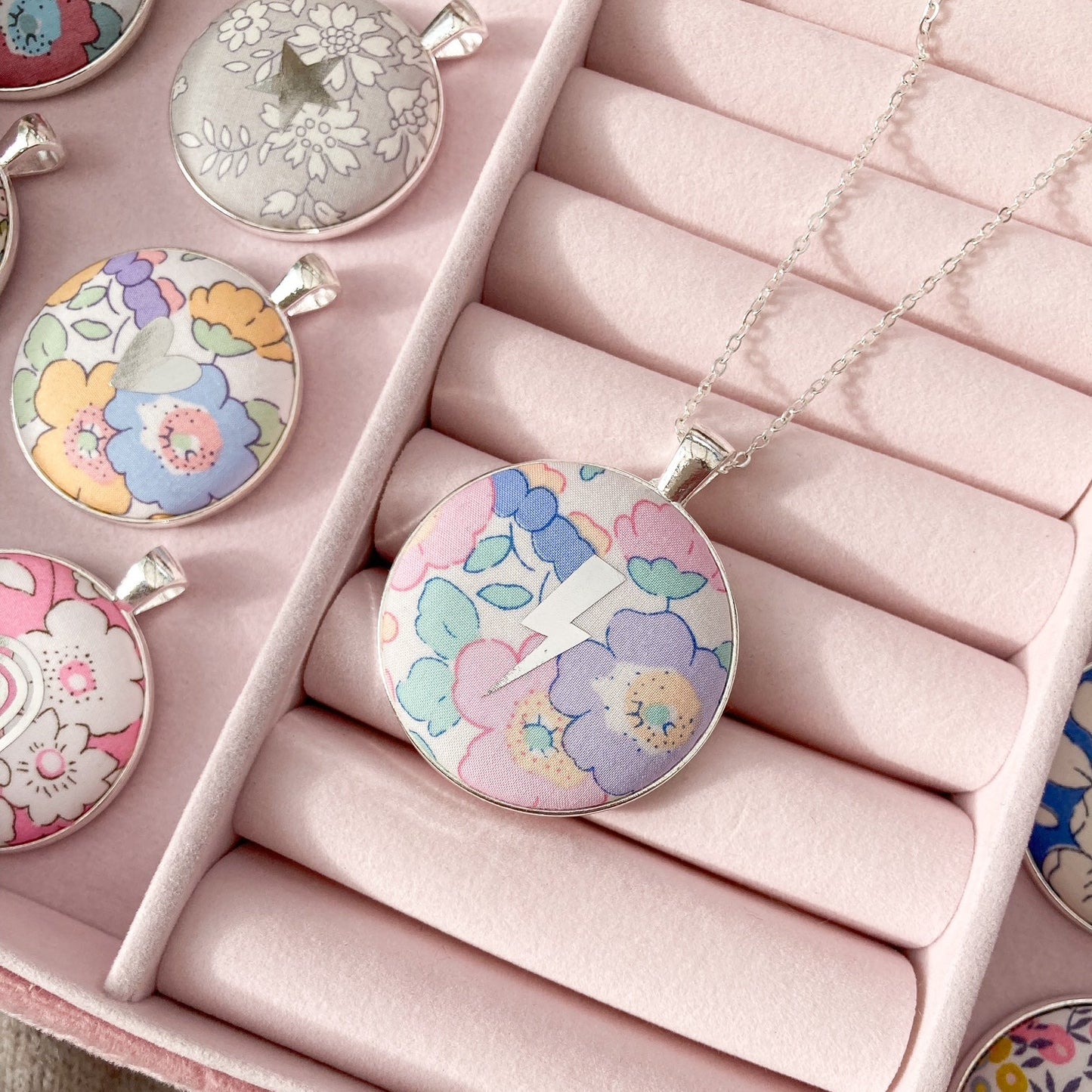 Floral pendant necklaces in a pink jewelry box