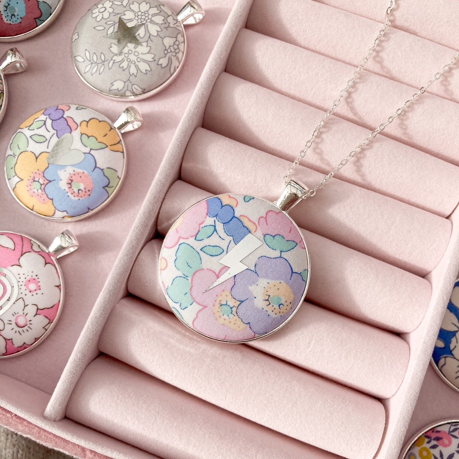 Floral pendant necklaces in a pink jewelry box