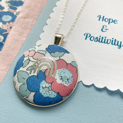 Floral pendant necklace with a fabric message saying 'Hope & Positivity'