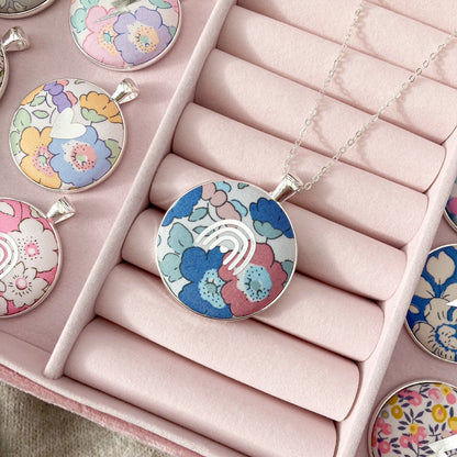 Colorful floral pendant necklaces in a pink jewelry box