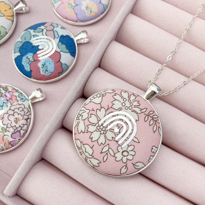 Decorative pendants with floral designs on a pink jewelry box