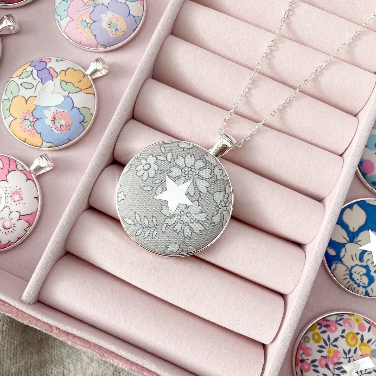 Grey Liberty fabric necklace with a star design in a pink jewellery box