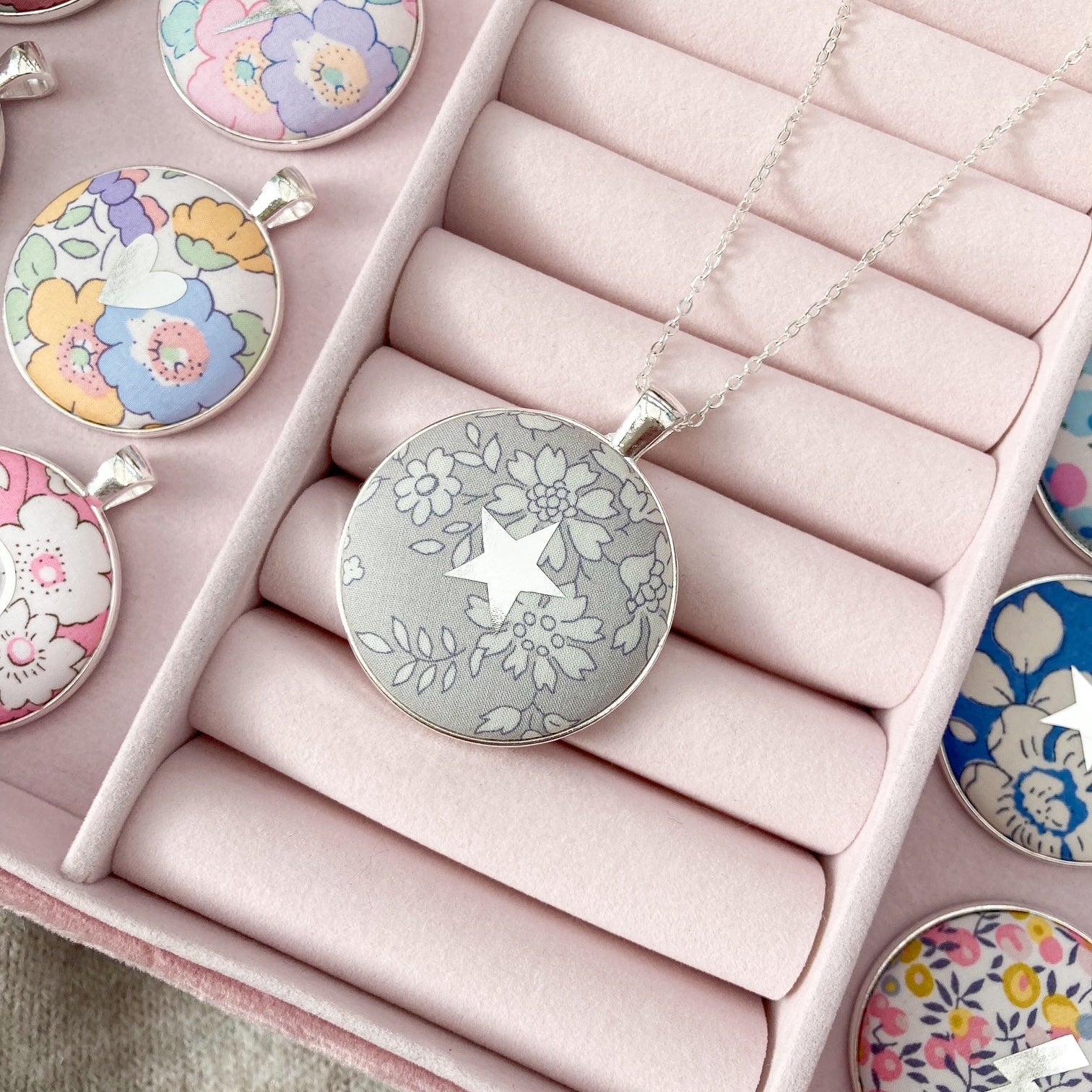 Grey Liberty fabric necklace with a star design in a pink jewellery box