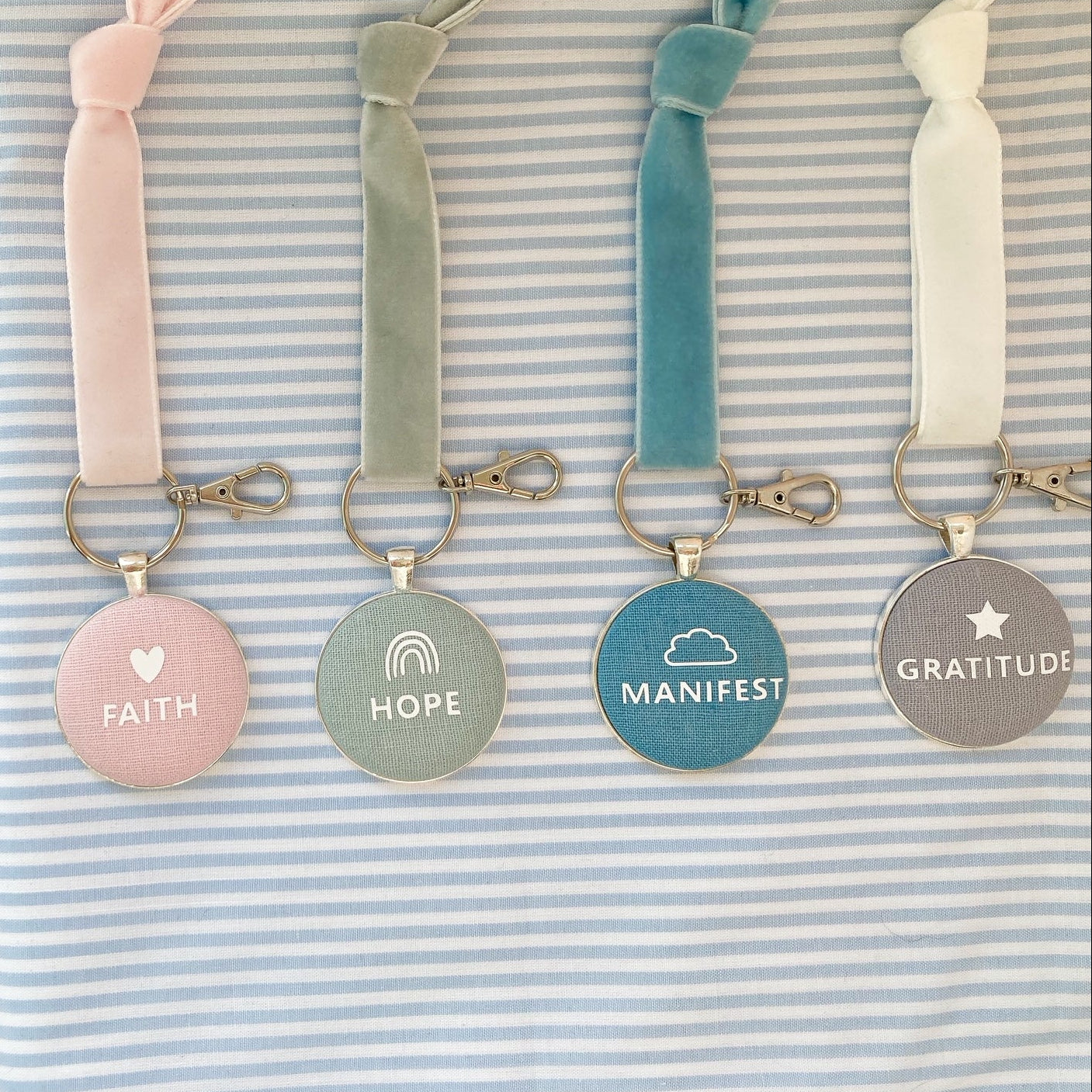 Set of keyrings with motivational phrases on a striped fabric background