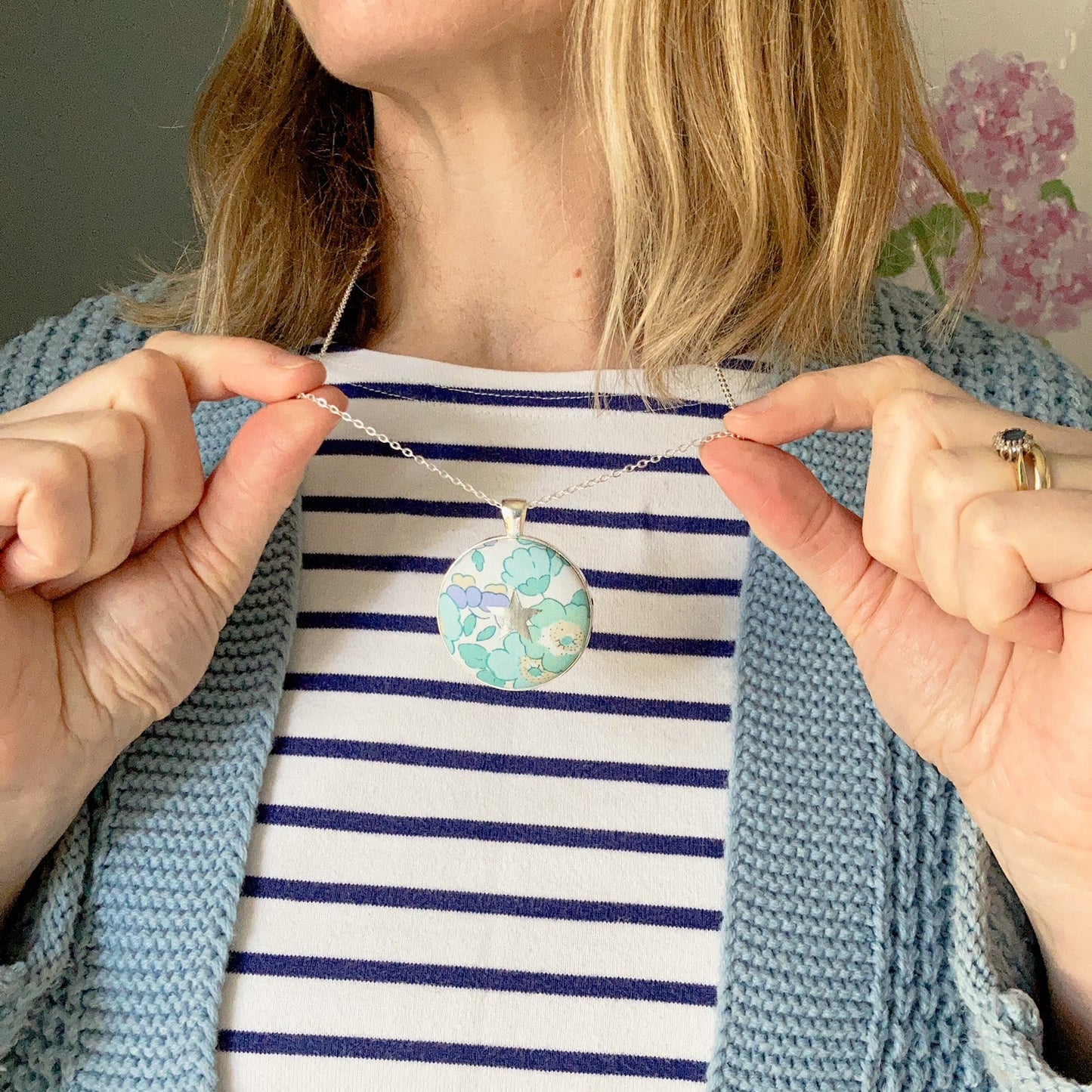 Lady wearing a lilac & mint floral necklace with a star design