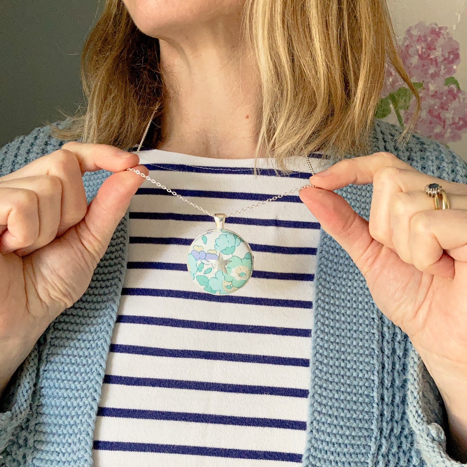 Lady wearing a lilac & mint floral necklace with a star design