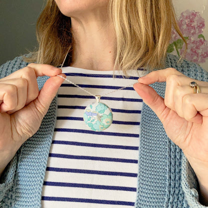 Lady wearing a lilac & mint floral necklace with a star design