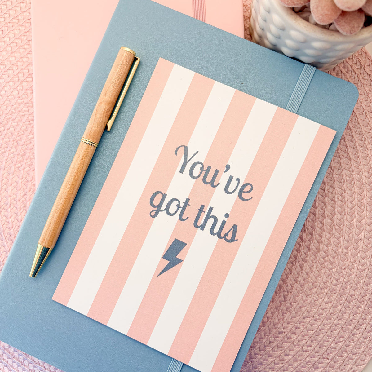 Pink and white striped postcard with You've Got This written in blue with a blue lightning symbol