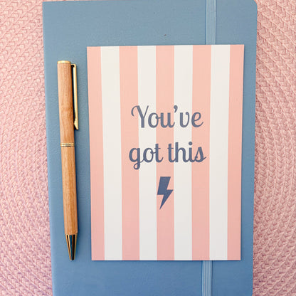 Pink and white striped postcard with You've Got This written in blue with a blue lightning symbol